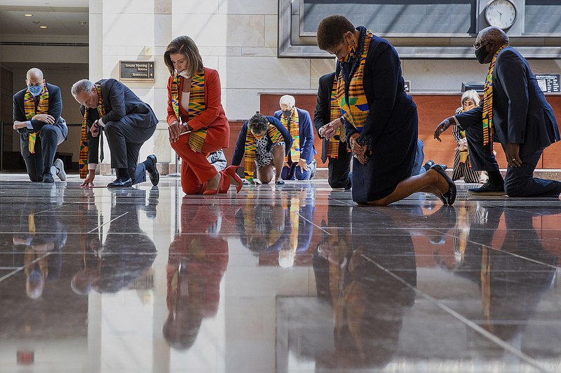 House Speaker Nancy Pelosi of Calif., center, and other members of Congress, kneel and observe a moment of silence at the Capitol's Emancipation Hall, Monday, June 8, 2020, on Capitol Hill in Washington, reading the names of George Floyd and others killed during police interactions. Democrats proposed a sweeping overhaul of police oversight and procedures Monday, an ambitious legislative response to the mass protests denouncing the deaths of black Americans at the hands of law enforcement. (AP Photo/Manuel Balce Ceneta)