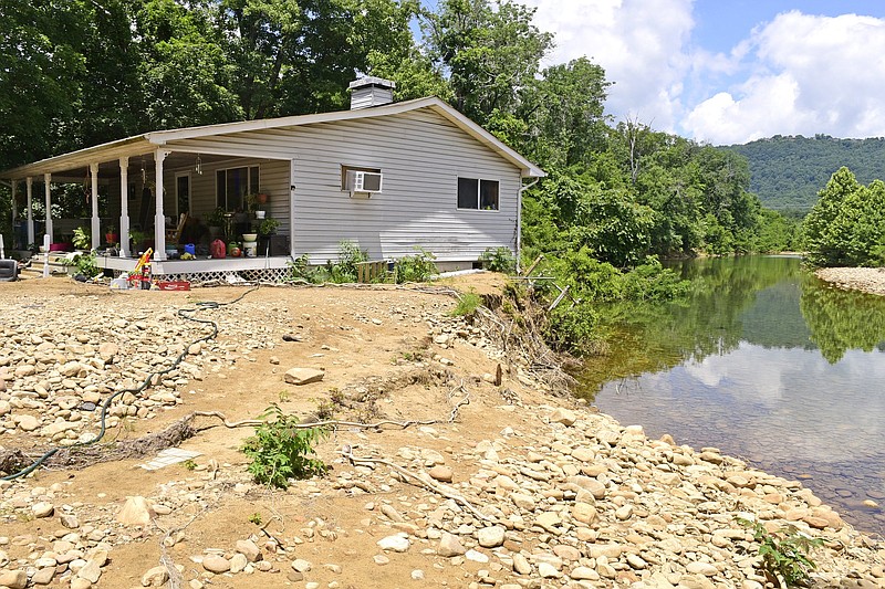 Staff Photo by Robin Rudd / The Pine Street home of Sandra and Jack Hayes hangs precariously on the edge of the bank. The Hayes' yard was also destroyed, exposing roots, tearing apart out-buildings and burying toys in rock and silt by the steam's recent flooding. Flooding and erosion have become a problem for homeowners along North Chickamauga Creek and Little Soddy Creek in Soddy-Daisy.