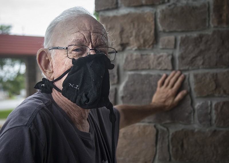 Staff photo by Troy Stolt / Arthur Rounsaville leans against a support beam at the entrance of Mary Walker Towers after being tested for the coronavirus on Monday, May 18, 2020 in Chattanooga, Tenn. He was wearing one of the state-distributed masks, made by a sock company.