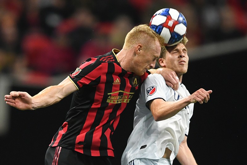 AP photo by John Amis / Atlanta United FC defender Jeff Larentowicz, left, and New England Revolution midfielder Scott Caldwell battle for a header during an MLS Cup playoff match on Oct. 19 2019, in Atlanta.