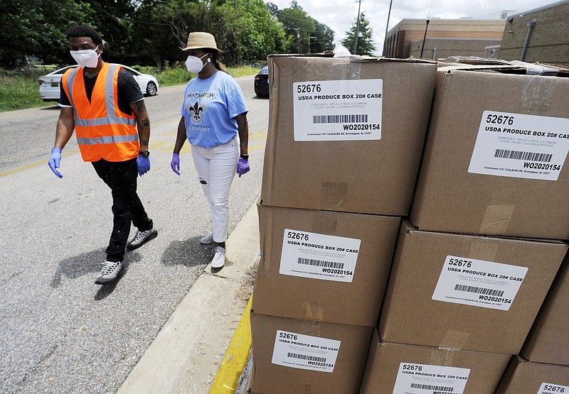 Volunteers walk past boxes full of fruit and produce at a site where free food was distributed to residents of Alabama's Black Belt region in Selma, Ala., on Thursday, June 4, 2020. Relief groups are trying to provide aid during the pandemic in the mostly black, historically poor region, which has the state's highest unemployment and coronavirus infection rates. (AP Photo/Jay Reeves)


