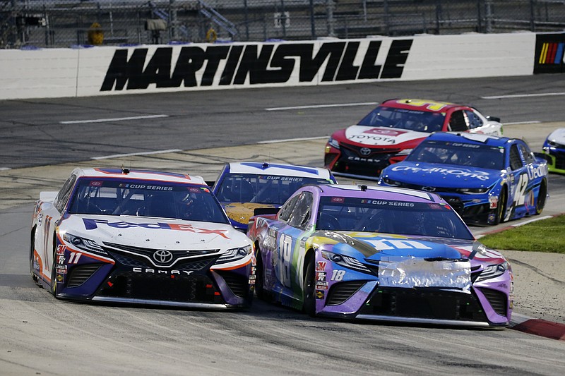 AP photo by Steve Helber / Joe Gibbs Racing teammates Denny Hamlin, left, and Kyle Busch, right, come through a turn during the NASCAR Cup Series race Wednesday night in Martinsville, Va.