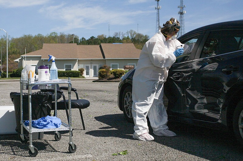 Staff photo by Wyatt Massey / Christy Botts, clinical manager at Physicians Services, swabs someone for a COVID-19 test in the parking lot of the Cleveland clinic on March 29, 2020.
