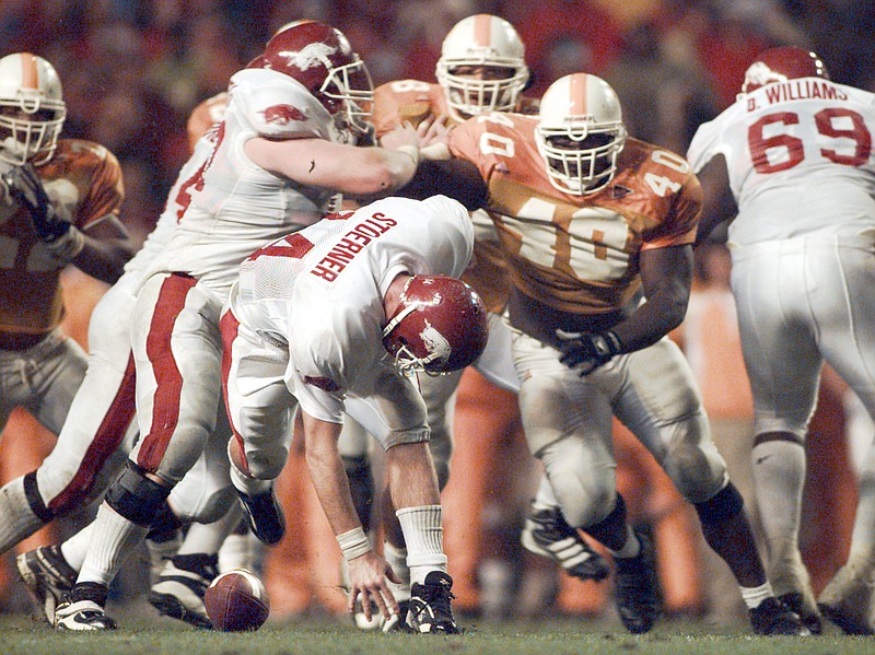 Arkansas Democrat-Gazette photo by David Gottschalk / Arkansas quarterback Clint Stoerner fumbles the ball during the final two minutes of the 28-24 loss at Tennessee on Nov. 14, 1998. In the background is Tennessee defensive tackle Billy Ratliff (40), who forced the fumble and would recover the ball as well.