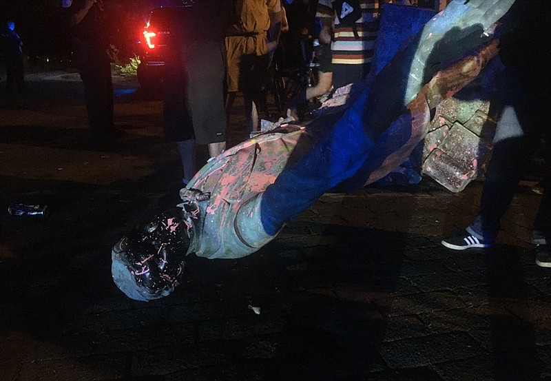 The statue of Confederate President Jefferson Davis is splattered with paint after it was toppled Wednesday night, June 10, 2020, along Monument Drive in Richmond, Va. (Dylan Garner/Richmond Times-Dispatch via AP)

