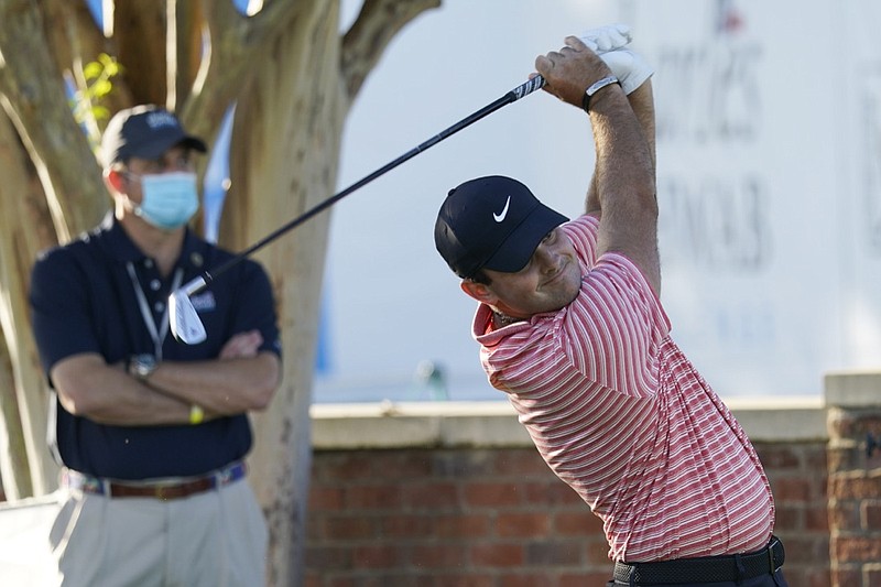 Coby Wooten, left, watches as Patrick Reed tees off at the 10th hole during the first round of the Charles Schwab Challenge golf tournament at the Colonial Country Club in Fort Worth, Texas, Thursday, June 11, 2020. (AP Photo/David J. Phillip)