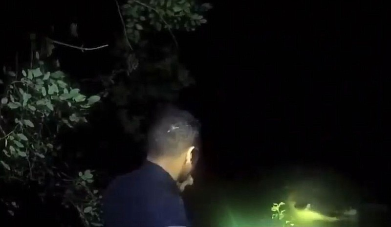Body camera footage shows an officer with a flashlight near the water's edge as a man moves in the water. / Winchester police	