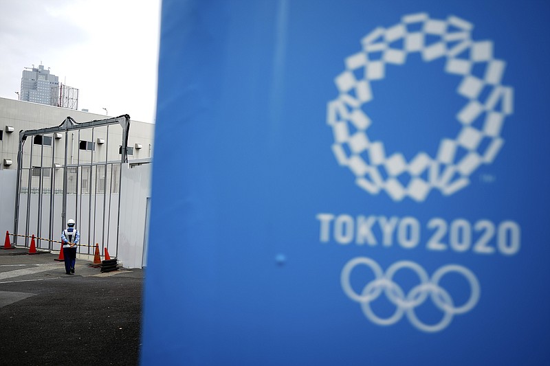 AP photo by Eugen Hoshiko / A lone security guard stands at one of the venues for the Tokyo 2020 Olympics on May 12. The Summer Games have been postponed until next year but will retain the Tokyo 2020 branding.