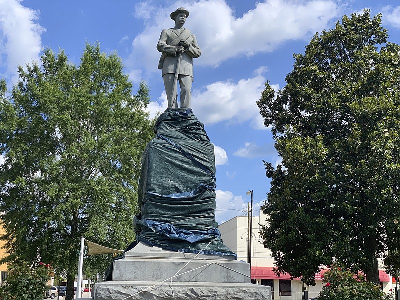 Macon County officials covered the base of a Confederate statue, Friday, June 12, 2020, in Tuskegee, Ala., after it was vandalized with spray-painted obscenities. The Alabama county is seeking to remove the statue that sits in a town square. (AP Photo/Kim Chandler)


