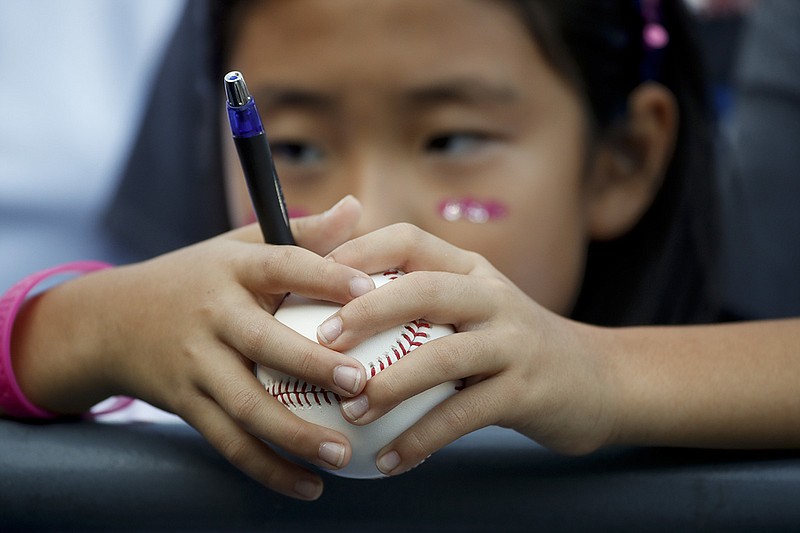AP photo by Jae C. Hong / A baseball fan waits for an autograph during batting practice before Game 2 of the National League Division Series between the Los Angeles Dodgers and the Atlanta Braves on Oct. 5, 2018, in Los Angeles.
