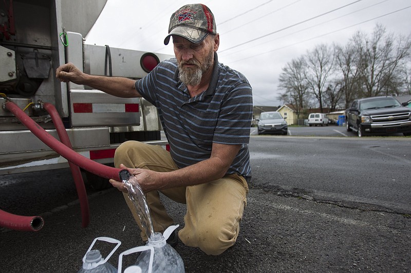 Staff photo by Troy Stolt / Summerville resident Billy Joe Durham filled up jugs of clean water behind city hall on Thursday, Feb. 13, 2020 in Summerville, Georgia. The city is now considering a rate hike to help pay for a solution to its water contamination issues.