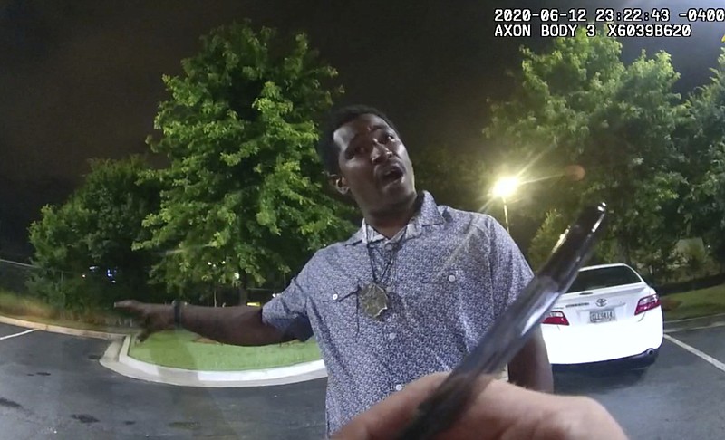 This screen grab taken from body camera video provided by the Atlanta Police Department shows Rayshard Brooks speaking with Officer Garrett Rolfe as Rolfe writes notes during a field sobriety test in the parking lot of a Wendy's restaurant, late Friday, June 12, 2020, in Atlanta. Rolfe has been fired following the fatal shooting of Brooks and a second officer has been placed on administrative duty. (Atlanta Police Department via AP)


