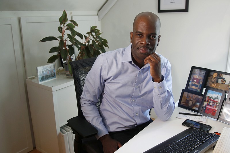 In this June 12, 2020 photo, Gregory Minott sits in his home office in Andover, Mass. Minott came to the U.S. from his native Jamaica more than two decades ago on a student visa and was able to carve out a career in architecture thanks to temporary work visas. Now a U.S. citizen and co-founder of a real estate development firm in Boston, he worries that new restrictions on student and work visas expected to be announced soon will prevent others from following a similar path to the American dream. (AP Photo/Elise Amendola)


