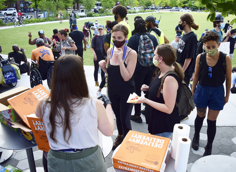 Staff Photo by Robin Rudd / A volunteer hands out pizza to protesters before the start of the march. Protesters gathered at Miller Park and marched south past some of Chattanooga's tourism icons in reaction to the killing of George Floyd and other police brutalities on June 17, 2020.