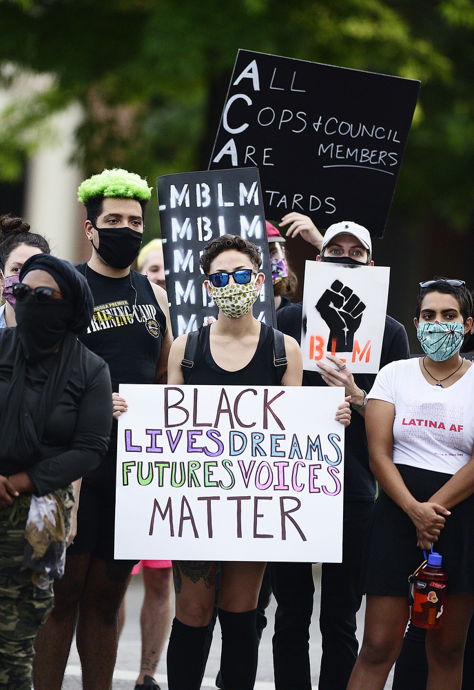 Staff Photo by Robin Rudd / Marchers hold signs as they pause at the intersection of Houston and Market Streets. Protesters gathered at Miller Park and marched south past some of Chattanooga's tourism icons in reaction to the killing of George Floyd and other police brutalities on June 17, 2020.