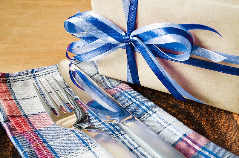 Festive Table Setting. Cutlery with Present on Linen Napkin on Rustic Wooden Background. Father's Day Concept. Copy Space. Selective Focus. father's day tile present tile gift tile food tile / Getty Images
