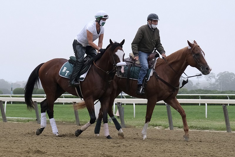 AP photo by Seth Wenig / Robin Smullen sits atop Belmont Stakes favorite Tiz the Law, left, as trainer Barclay Tagg, right, leads the colt around the track during a workout Friday at Belmont Park in Elmont, N.Y.