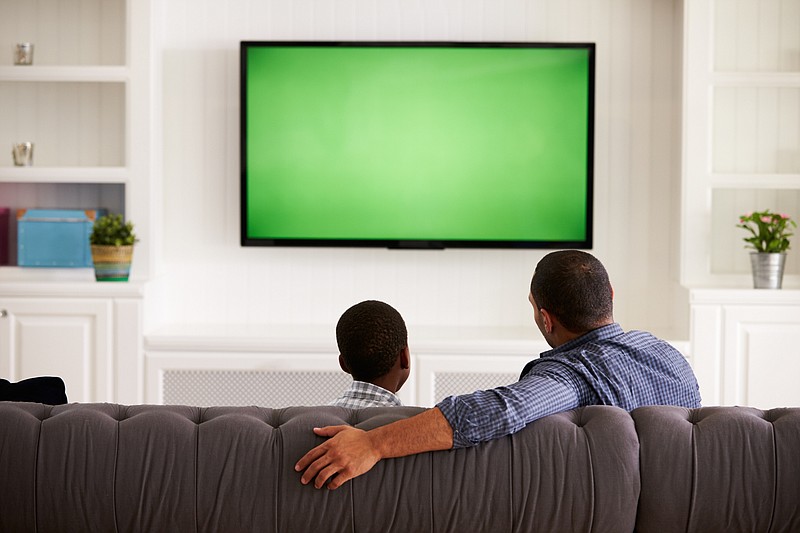 Dad and son watching tv tile / Getty Images