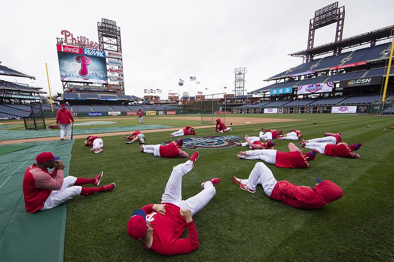 AP photo by Matt Rourke / The Philadelphia Phillies stretch before a home game against the Washington Nationals on April 6, 2017. Five players for the Phillies have tested positive for COVID-19 at the team's spring camp in Florida, prompting the club to indefinitely close the complex. The team also said that three staff members have tested positive.