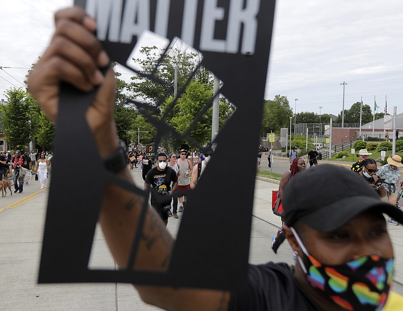 The Associated Press / A Seattle protester taking part in a Juneteenth march for nonviolence holds up a stencil of a fist.