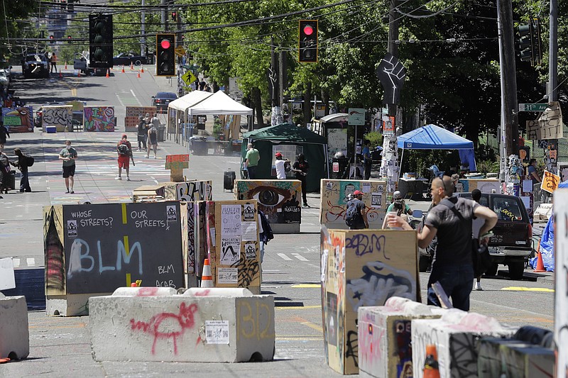 People walk amidst barricades in what has been named the Capitol Hill Occupied Protest zone in Seattle Monday, June 22, 2020. For the second time in less than 48 hours, there was a shooting near the "CHOP" area that has been occupied by protesters after Seattle Police pulled back from several blocks of the city's Capitol Hill neighborhood near the Police Department's East Precinct building. (AP Photo/Ted S. Warren)


