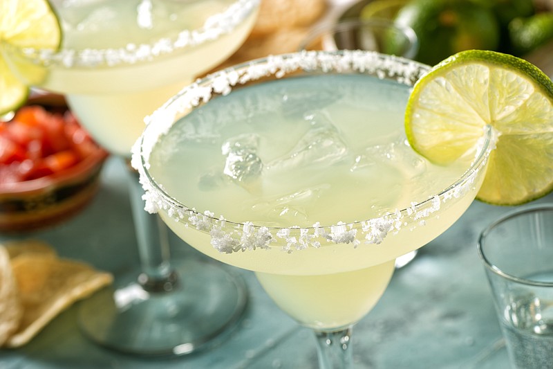 Delicious tequila and lime margaritas on an outdoor table with tortilla chips and pico de gallo. drink tile food tile margarita tile alcohol tile / Getty Images
