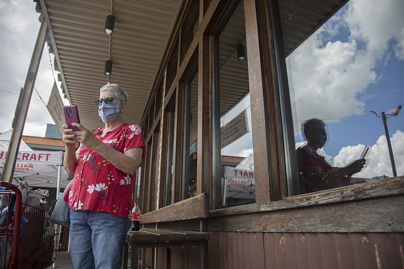Staff photo by Troy Stolt / "I only go out when I absolutely have to," Kathryn Wright says as she checks on her Uber after shopping at the Family Dollar on Market Street on Thursday, May 28, 2020 in Chattanooga, Tenn. "I'm always nervous when I have to, not enough people are wearing masks".