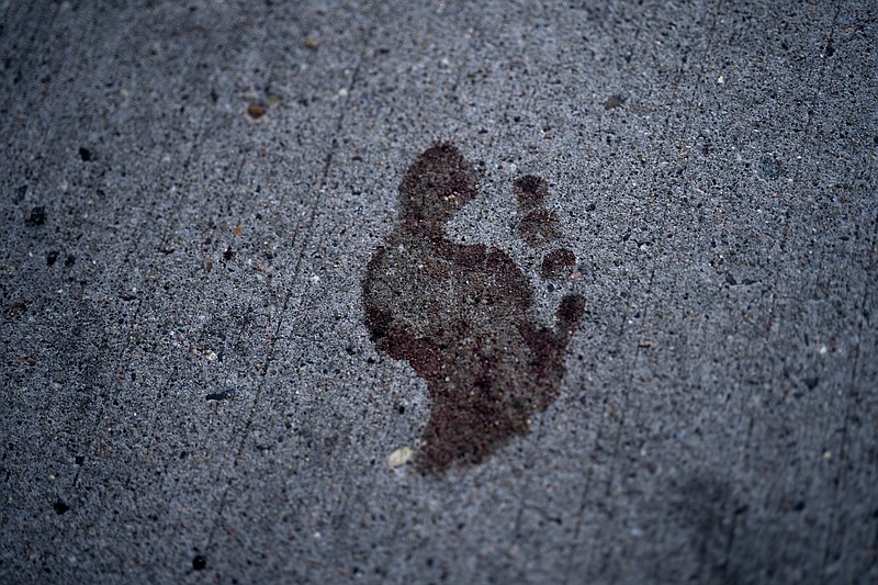 A bare bloody footprint remains on the sidewalk in the 2900 block of Hennepin Avenue after an early morning shooting, Sunday, June 21, 2020, in Minneapolis' Uptown neighborhood. The shooting in the popular nightlife area early Sunday left one man dead and multiple people wounded in a chaotic scene that sent people ducking into restaurants and other businesses for cover. (Jerry Holt/Star Tribune via AP)


