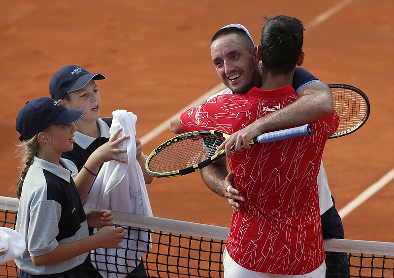 In this Saturday, June 13, 2020 photo, Serbia's Novak Djokovic, front right, hugs with Serbia's Viktor Troicki after their match of the Adria Tour charity tournament in Belgrade, Serbia. Novak Djokovic has tested positive for the coronavirus after taking part in a tennis exhibition series he organized in Serbia and Croatia. The top-ranked Serb is the fourth player to test positive for the virus after first playing in Belgrade and then again last weekend in Zadar, Croatia. Viktor Troicki said Tuesday that he and his pregnant wife have both been diagnosed with the virus. (AP Photo/Darko Vojinovic)