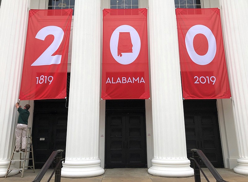 In this Feb. 28, 2019, photo a worker adjusts a banner celebrating Alabama's bicentennial outside the Department of Archives and History in Montgomery, Ala. Alabama's main state history agency is acknowledging that it helped perpetuate systemic racism by promoting Confederate narratives while ignoring those of Black people, a "statement of recommitment" issued Tuesday, June 23, 2020 by the Alabama Department of Archives and History said. (AP Photo/Jay Reeves, File)


