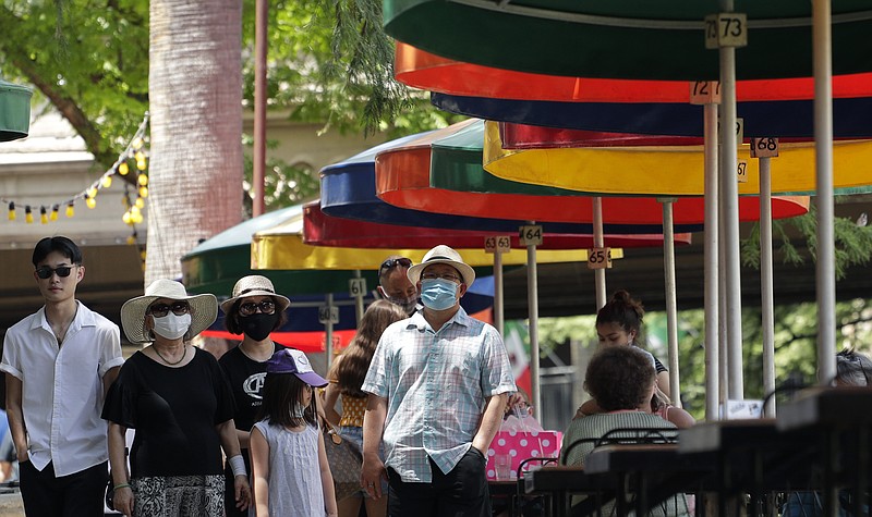 Visitors, some wearing masks to protect against the spread of COVID-19, walk along the River Walk in San Antonio, Wednesday, June 24, 2020, in San Antonio. Cases of COVID-19 have spiked in Texas and the governor of Texas is encouraging people to wear masks in public and stay home if possible. (AP Photo/Eric Gay)


