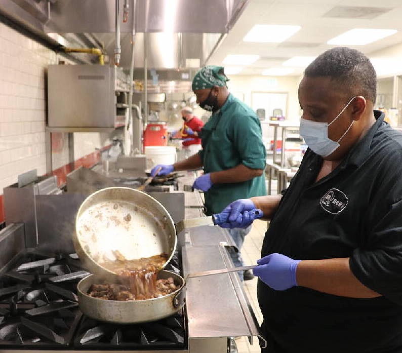 Contributed photo by Rebecca Feldbin / Pat Rowe of BBQ Rowe and Catering, with Terrence Locke of Chef Express behind him, working side by side in LAUNCH's Kitchen Incubator of Chattanooga.