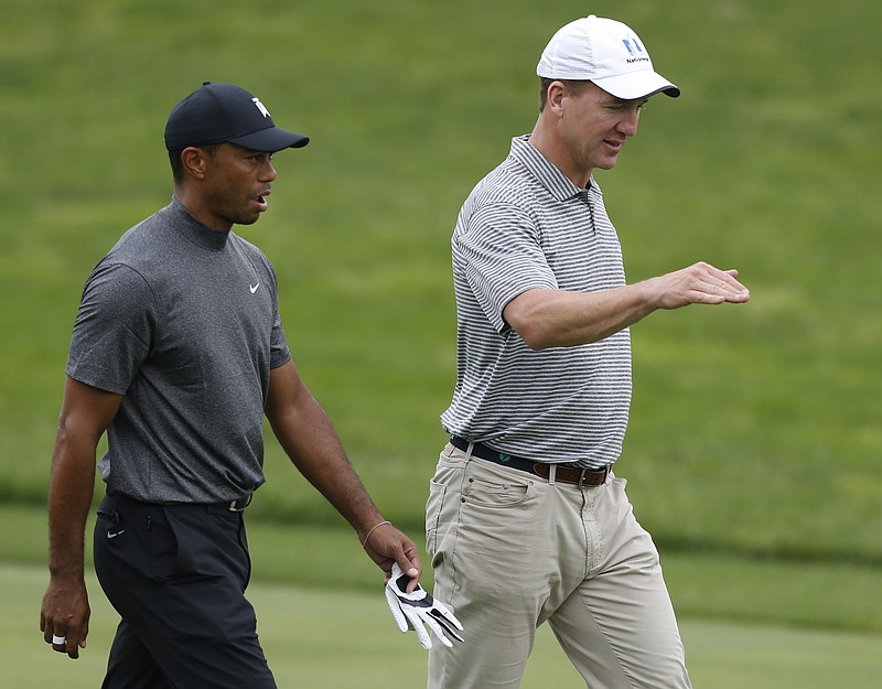 Photo by Jay LaPrete/The Associated Press Images for NFL / Former NFL player Peyton Manning, right, talks with Tiger Woods while playing in the pro-am round of the Memorial golf tournament on May 29, 2019, in Dublin, Ohio.