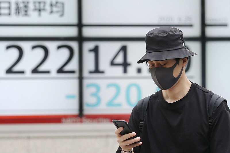 A man walks by an electronic stock board of a securities firm in Tokyo, Thursday, June 25, 2020. Shares declined in Asia on Thursday after a sharp retreat overnight on Wall Street as new coronavirus cases in the U.S. climbed to their highest level in two months, dimming investors' hopes for a relatively quick economic turnaround. (AP Photo/Koji Sasahara)


