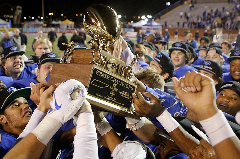 Staff photo by C.B. Schmelter / McCallie football players hoist the TSSAA Division II-AAA state championship trophy after beating Montgomery Bell Academy in the BlueCross Bowl this past Dec. 5 at Tennessee Tech.