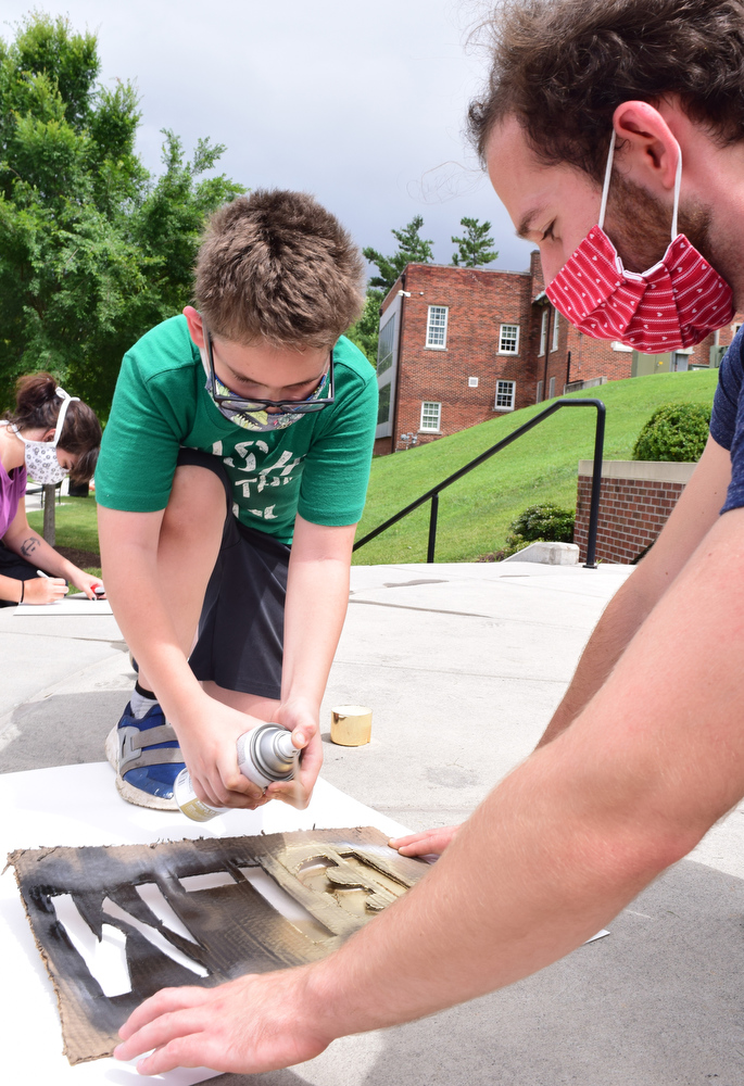 Staff Photo by Robin Rudd / Bradley Allen sprays paint while UTC student Bennett Bowden as they make a Black Lives Matter sign. UTC students and the Chattanooga community held a demonstration at the school's Chamberlain Field to show solidarity with Black Lives Matter.