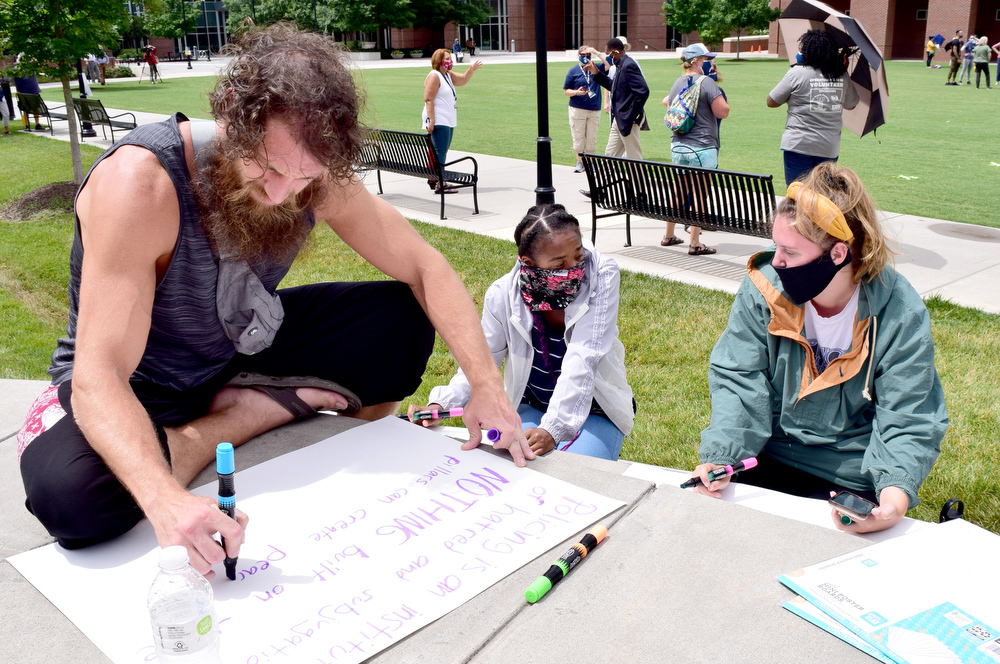 Staff Photo by Robin Rudd / From left, Favbo Anu, and UTC students Carissa Conley and Haley Roberts Carr make signs before the rally. UTC students and the Chattanooga community held a demonstration at the school's Chamberlain Field to show solidarity with Black Lives Matter.