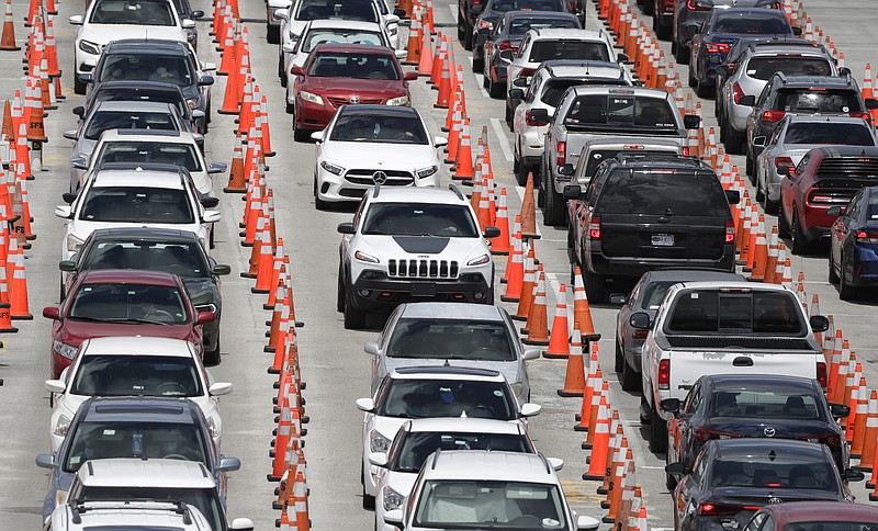 Lines of cars wait at a coronavirus testing site outside of Hard Rock Stadium, Friday, June 26, 2020, in Miami Gardens, Fla. Florida banned alcohol consumption at its bars Friday as its daily confirmed coronavirus cases neared 9,000, a new record that is almost double the previous mark set just two days ago. (AP Photo/Wilfredo Lee)


