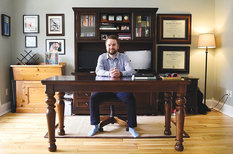 Staff Photo by Robin Rudd / C.J. Recher is pictured at the desk in his home office.