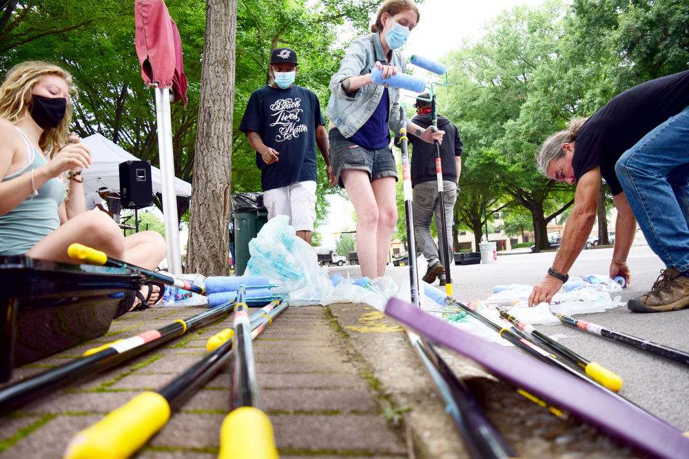 Staff Photo by Robin Rudd / Volunteers ready paint rollers on the second and final day of the project on Martin Luther King Jr. Blvd.. According to Shane Morrow, of Rise Chattanooga who funded the mural, the huge painting of "Black Lives Matter !" was a "symbol of hope" and "a opportunity for conversation and gathering community."