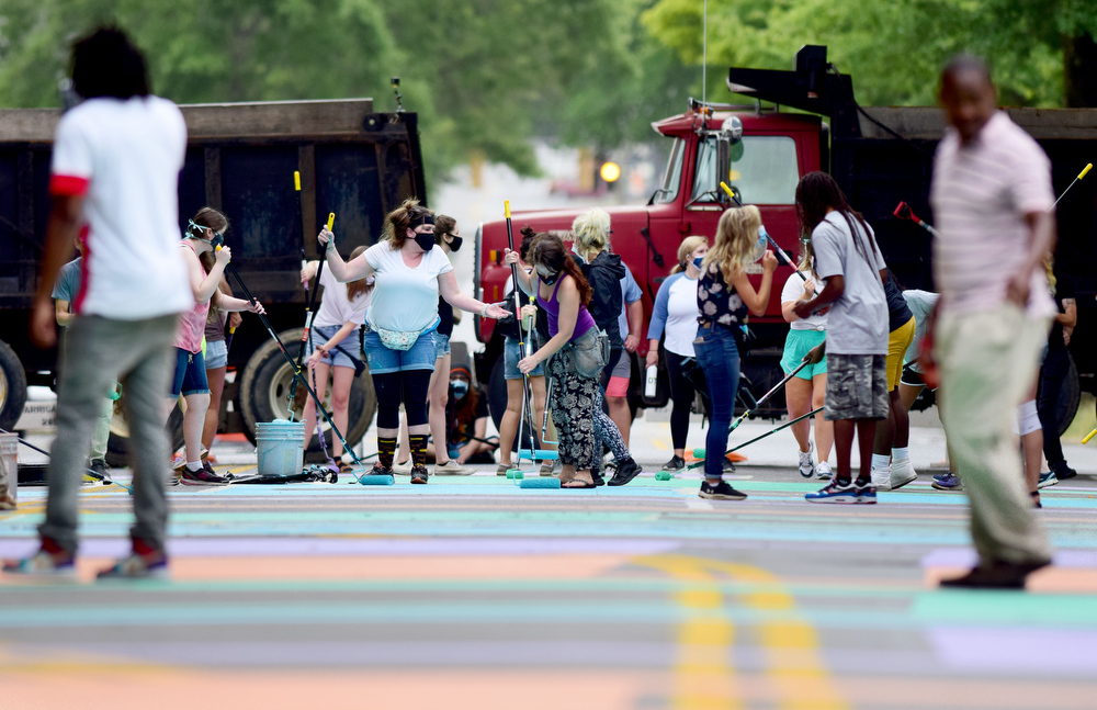 Staff Photo by Robin Rudd / Volunteers near completion of the "Black Lives Matter !" on Martin Luther King Jr. Blvd..