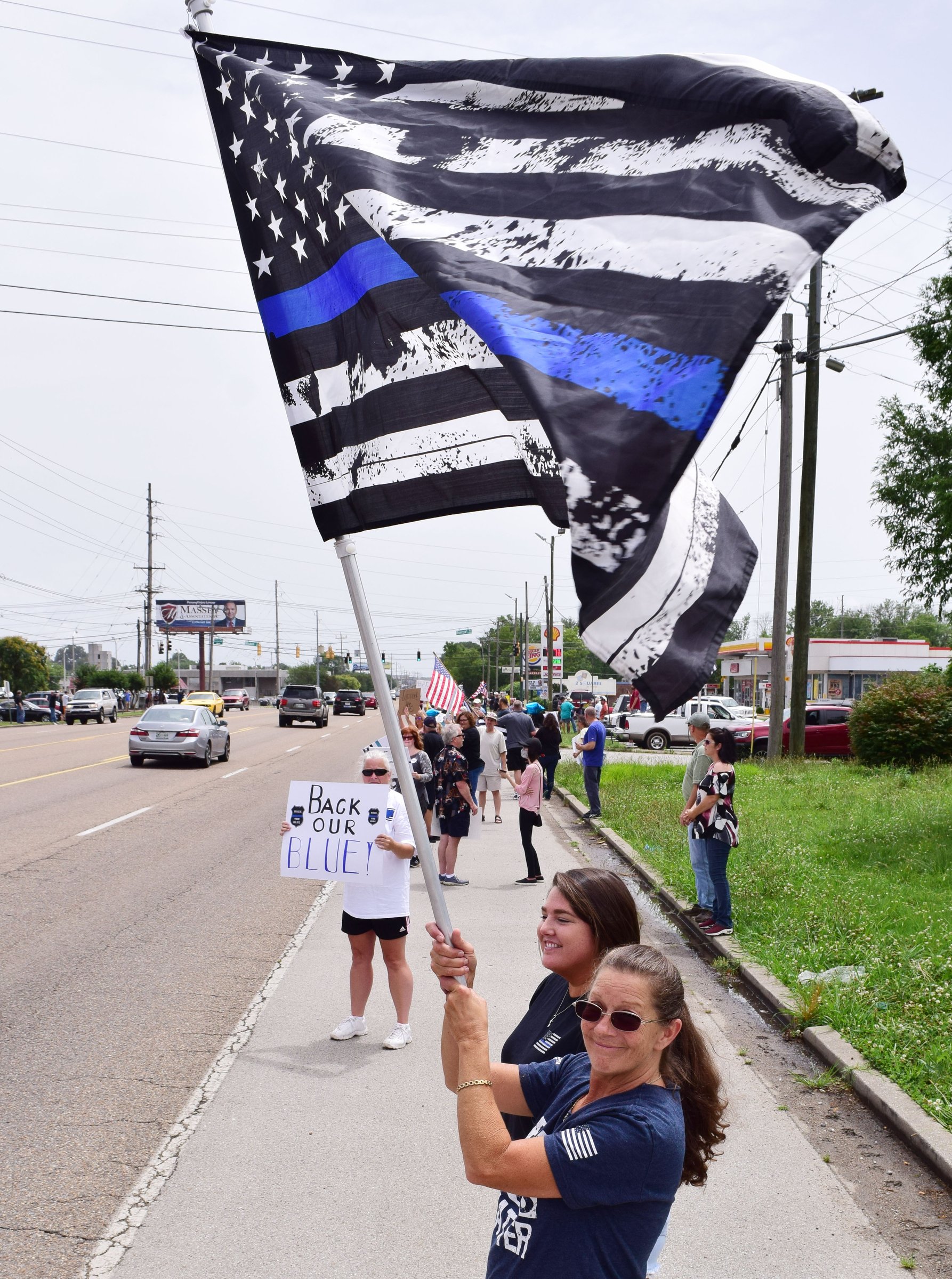 Staff Photo by Robin Rudd / Terisa Allen hold's her son's Thin Blue Line American Flag high at the rally. People gathered, June 27, 2020, along Amnicola Highway, in front of the Chattanooga Police Services Building, to rally in support of area police.