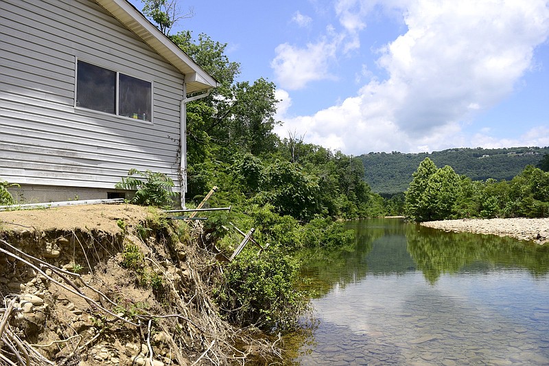 Staff Photo by Robin Rudd / The Pine Street home of Sandra and Jack Hayes hangs precariously on the edge of the bank.  Mr. Hayes yard was also destroyed, exposing roots, tearing a part out-buildings and burying toys in rock and silt by the steams recent flooding.  Flooding and erosion have become a problem for homeowners along North Chickamauga Creek and Little Soddy Creek in Soddy-Daisy.  