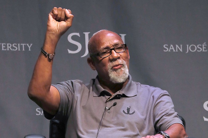 AP photo by Tony Avelar / John Carlos, who competed for the United States at the 1968 Mexico City Olympics, raises his fist on Oct. 17, 2018, at San Jose State University as he speaks about his experience protesting on the medal stand alongside teammate Tommie Smith.