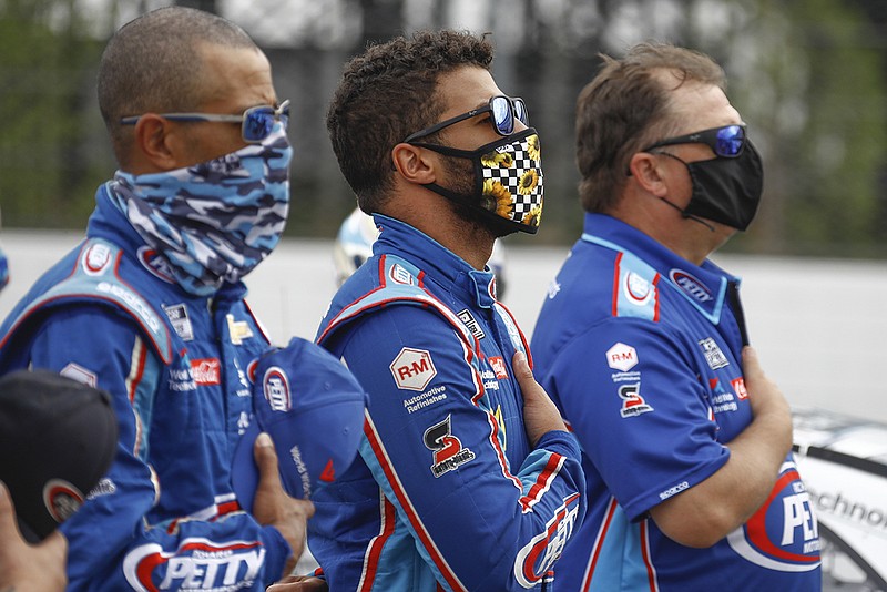 AP photo by Matt Slocum / NASCAR driver Bubba Wallace, center, stands with his crew during the playing of the national anthem before Saturday's Cup Series event at Pocono Raceway in Long Pond, Pa.