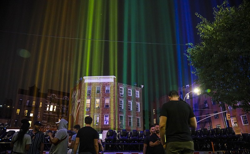 A rainbow light display illuminates the night sky in the West Village near The Stonewall Inn, birthplace of the gay rights movement, Saturday, June 27, 2020, in New York. The light installation was presented by Kind snack foods to mark what would have been the 50th anniversary of the NYC Pride March, which is canceled this year because of the coronavirus pandemic. (AP Photo/Bebeto Matthews)