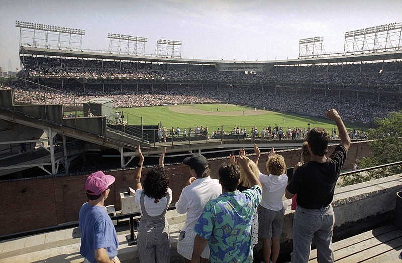 AP photo by Seth Perlman / Spectators watch an All-Star Game practice session from the roof of a building just outside Wrigley Field, the home of the Chicago Cubs, on July 9, 1990.