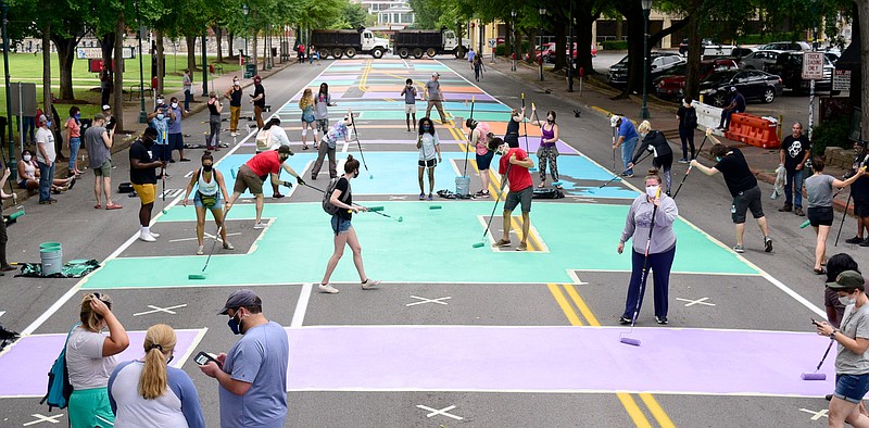 Staff Photo By Robin Rudd / The last letters of "Black Lives Matter!" are filled in to complete a mural on Martin Luther King Jr. Boulevard last weekend.