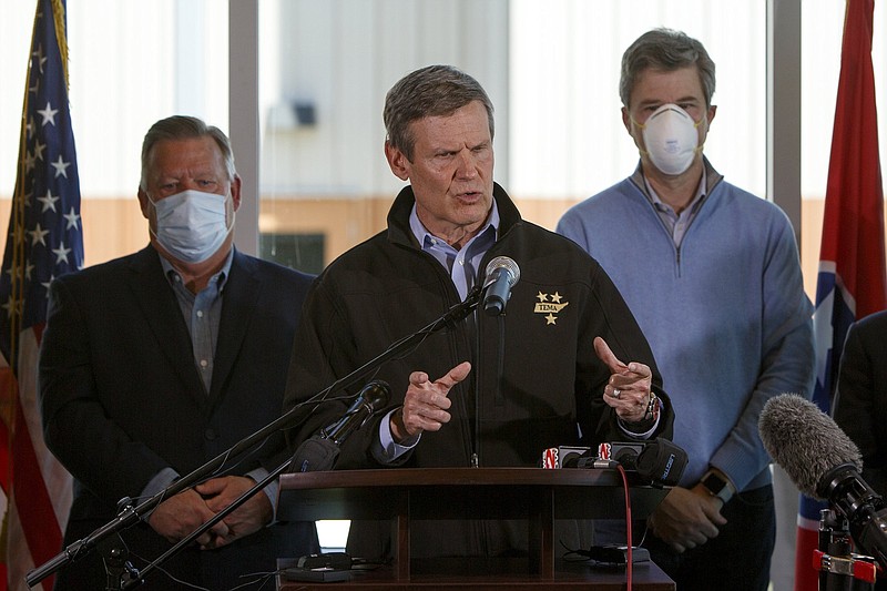 Staff file photo, C.B. Schmelter / Flanked by Chattanooga Mayor Andy Berke, right, and Hamilton County Mayor Jim Coppinger, Gov. Bill Lee speaks during in mid-April in Chattanooga, after violent storms and a tornado tore through eastern Hamilton County and Northwest Georgia even amid a COVID-19 outbreak.