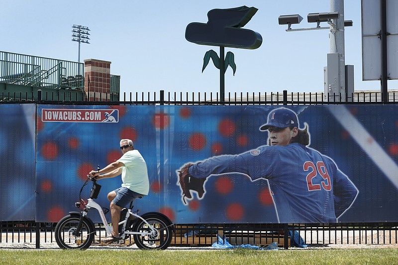 AP photo by Charlie Neibergall / A cyclist rides past Principal Park, home of the Triple-A Iowa Cubs, on June 25 in Des Moines. Minor league baseball won't be played in 2020 due to the coronavirus pandemic.